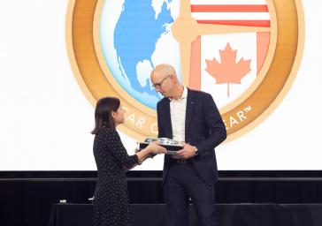 NACTOY Board of Directors Secretary Jill Ciminillo (left) presents the 2025 North American Car of the Year™ award to American Honda Zone Manager Josh Beckner at the NACTOY announcements in Detroit on January 10, 2025.