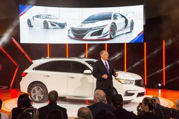 Art St. Cyr, president of Honda Performance Development, presents the Acura NSX GT3 race car (on screen) at the 2016 New York International Auto Show on March 23, 2016.