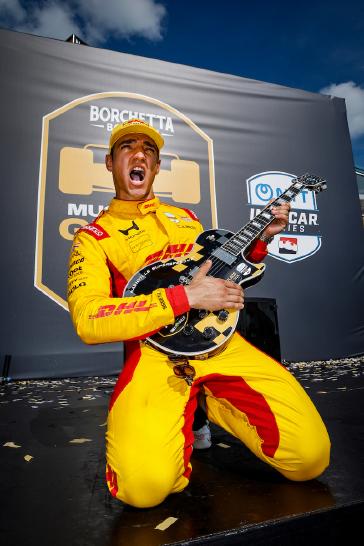 Winner #10: Alex Palou, Chip Ganassi Racing Honda celebrates with his Gibson guitar trophy  on the podium