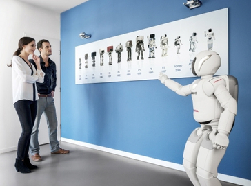 ASIMO shows visitors a timeline of Honda's robotic research.