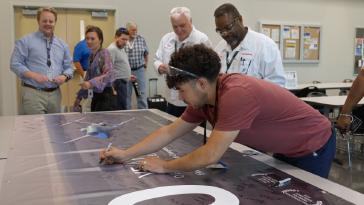 Associates marked two decades of excellence, continued innovation, and commitment to the Piedmont Triad community with a commemorative banner signing.
