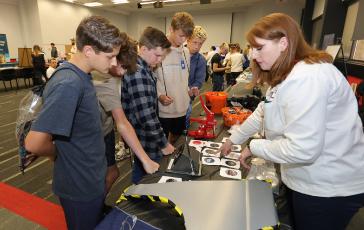 Students participate in a stamping activity with a Honda associate during MFG Day activities at the Marysville Auto Plant in Ohio