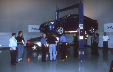 Representatives from aftermarket performance parts companies inspect the suspension of the new 2001 Acura RSX at American Honda's R&D facilities in Torrance, California.
